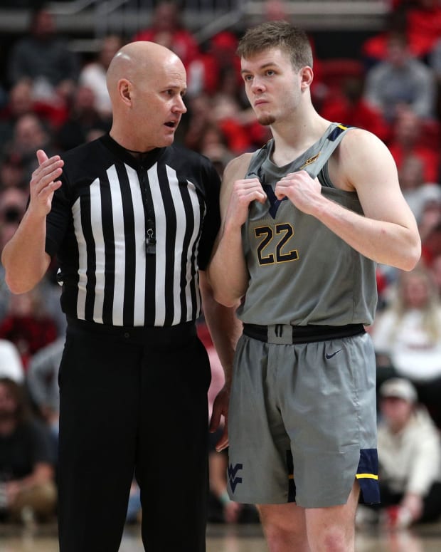Jan 22, 2022; Lubbock, Texas, USA; West Virginia Mountaineers guard Sean McNeil (22) visits with Big 12 official Kipp Kissinger in the second half during the game against the Texas Tech Red Raiders at United Supermarkets Arena.