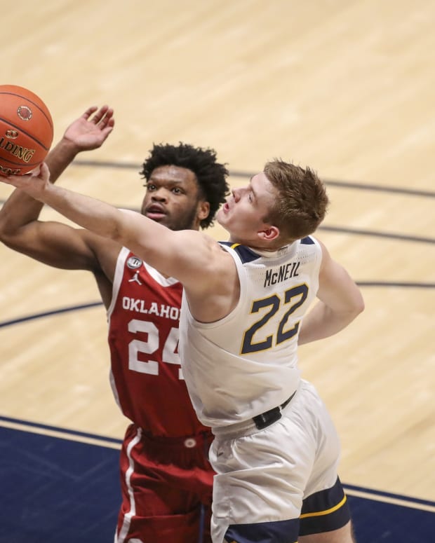Feb 13, 2021; Morgantown, West Virginia, USA; West Virginia Mountaineers guard Sean McNeil (22) drives and shoots against Oklahoma Sooners guard Elijah Harkless (24) during overtime at WVU Coliseum.