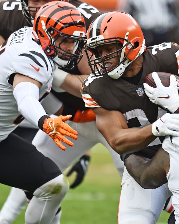 Jan 9, 2022; Cleveland, Ohio, USA; Cincinnati Bengals linebacker Markus Bailey (51) and defensive tackle Mike Daniels (76) tackle Cleveland Browns running back Nick Chubb (24) during the first quarter at FirstEnergy Stadium. Mandatory Credit: Ken Blaze-USA TODAY Sports