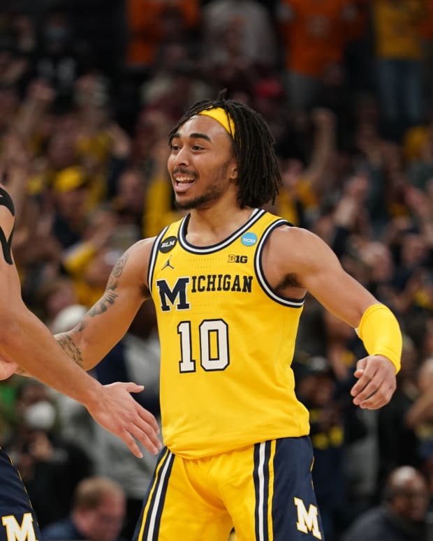 Michigan basketball players Frankie Collins and Terrence Williams II celebrate after a play.