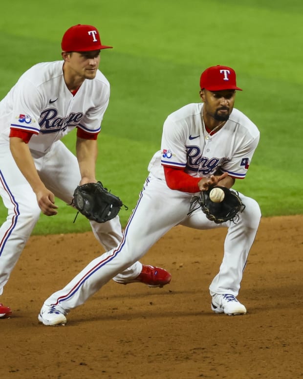 Apr 12, 2022; Arlington, Texas, USA; Texas Rangers second baseman Marcus Semien (2) fields a ground ball in front of Texas Rangers shortstop Corey Seager (5) during the fifth inning against the Colorado Rockies at Globe Life Field. Mandatory Credit: Kevin Jairaj-USA TODAY Sports