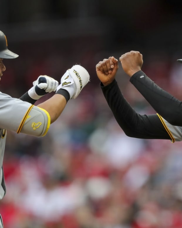 May 7, 2022; Cincinnati, Ohio, USA; Pittsburgh Pirates first baseman Yoshi Tsutsugo (25) high fives third baseman Ke'Bryan Hayes (13) after hitting a solo home run against the Cincinnati Reds in the first inning at Great American Ball Park. Mandatory Credit: Katie Stratman-USA TODAY Sports