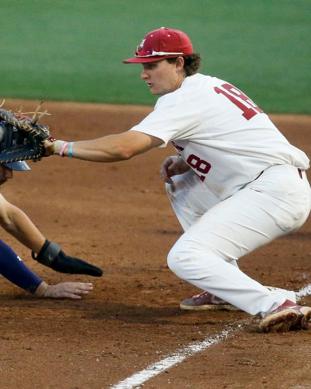 Alabama first baseman Drew Williamson (18) takes a pick off throw at first but can't tag out Auburn base runner Cole Foster in Sewell-Thomas Stadium Thursday, April 15, 2021
