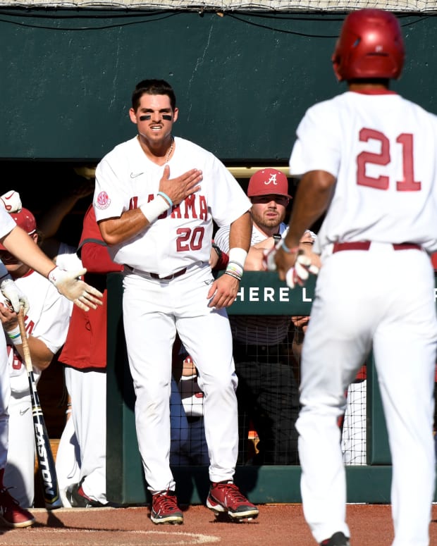 Alabama outfielder Tommy Seidl (20) and other players wait to greet Alabama outfielder Andrew Pinckney (21) after he scored on a wild pitch while playing against Murray State at Sewell-Thomas Stadium Friday, March 4, 2022.