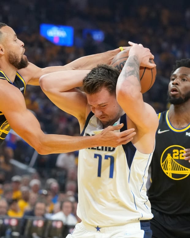 May 18, 2022; San Francisco, California, USA; Dallas Mavericks guard Luka Doncic (77) is defended by Golden State Warriors guard Stephen Curry (30) and forward Andrew Wiggins (22) during the first quarter in game one of the 2022 western conference finals at Chase Center. Mandatory Credit: Kyle Terada-USA TODAY Sports