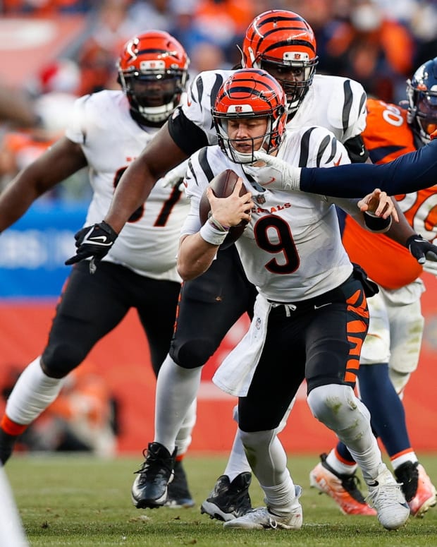 Cincinnati Bengals quarterback Joe Burrow (9) is face masked by Denver Broncos defensive tackle McTelvin Agim (95) in the third quarter at Empower Field at Mile High.