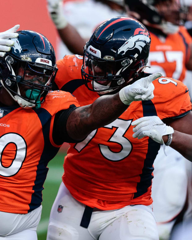 Denver Broncos defensive tackle DeShawn Williams (90) celebrates his sack with defensive end Dre'Mont Jones (93) in the third quarter against the Miami Dolphins at Empower Field at Mile High.
