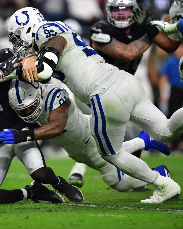 Nov 13, 2022; Paradise, Nevada, USA; Las Vegas Raiders quarterback Derek Carr (4) is brought down by Indianapolis Colts defensive tackle DeForest Buckner (99) defensive end Yannick Ngakoue (91) and safety Julian Blackmon (32) and during the second half at Allegiant Stadium.