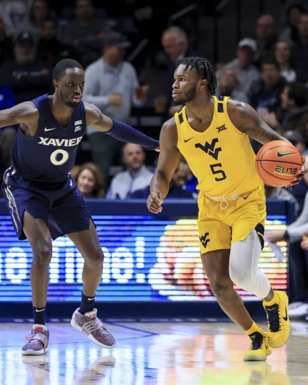 Dec 3, 2022; Cincinnati, Ohio, USA; West Virginia Mountaineers guard Joe Toussaint (5) controls the ball against Xavier Musketeers guard Souley Boum (0) in the first half at Cintas Center.