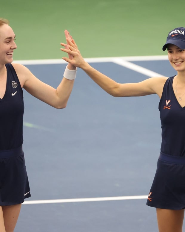 Julia Adams and Melodie Collard celebrate after scoring a point in doubles play during the Virginia women's tennis match against James Madison at Boar's Head Sports Club.