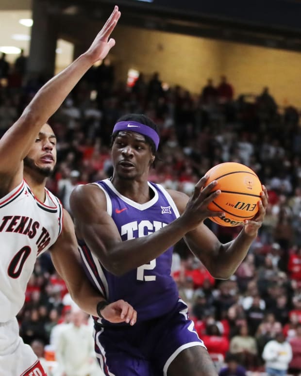 TCU Horned Frogs forward Emanuel Miller (2) fights for position against Texas Tech Red Raiders forward Kevin Obanor (0) in the first half at United Supermarkets Arena.