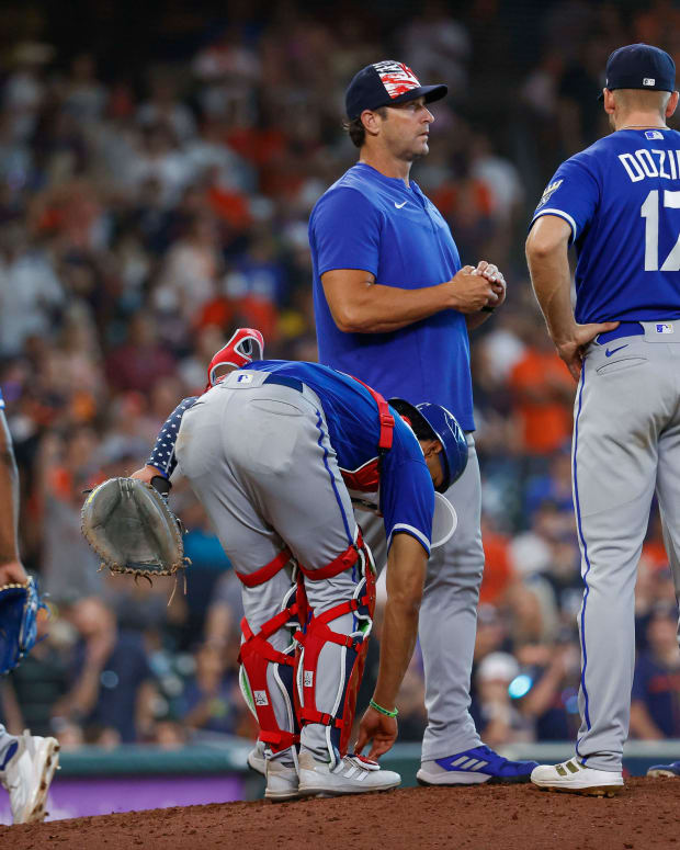 Jul 4, 2022; Houston, Texas, USA; Kansas City Royals manager Mike Matheny (22) holds a ball and relief pitcher Amir Garrett (24) walks off the mound after a pitching change during the eighth inning against the Houston Astros at Minute Maid Park. Mandatory Credit: Troy Taormina-USA TODAY Sports