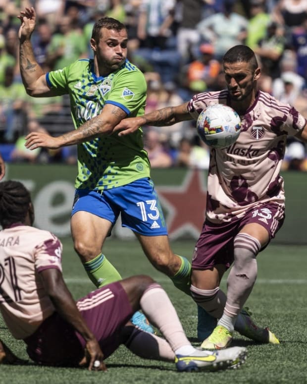 Jul 9, 2022; Seattle, Washington, USA; Portland Timbers defender Dario Zuparic (13) and midfielder Diego Chara (21) clear the ball away from Seattle Sounders FC forward Jordan Morris (13) during the second half at Lumen Field. Mandatory Credit: Stephen Brashear-USA TODAY Sports