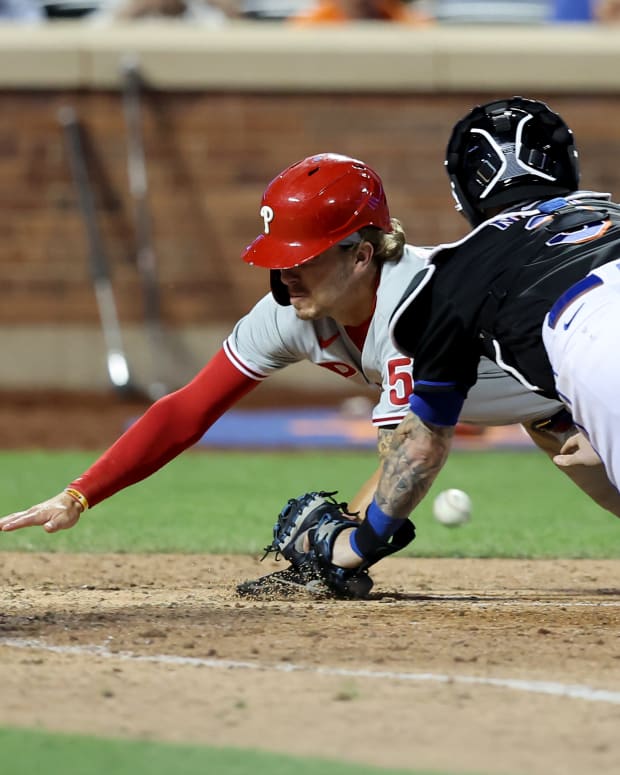 Aug 12, 2022; New York City, New York, USA; Philadelphia Phillies shortstop Bryson Stott (5) scores as he knocks the ball away from New York Mets catcher Tomas Nido (3) on a sacrifice fly by third baseman Alec Bohm (not pictured) during the tenth inning at Citi Field.