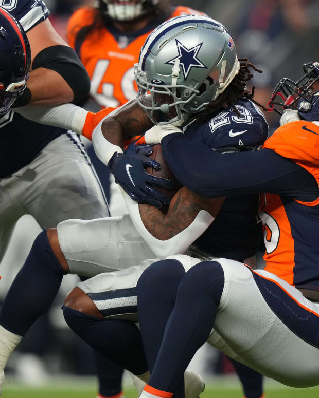 Denver Broncos linebacker Baron Browning (56) tackles Dallas Cowboys running back Rico Dowdle (23) in the first quarter at Empower Field at Mile High.