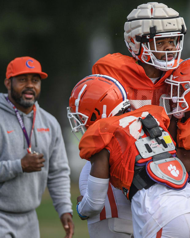 Clemson cornerbacks coach Mike Reed watches cornerback Malcolm Greene (21) and safety Kylon Griffin (18) lift linebacker Jeremiah Trotter Jr. (54) during practice in Clemson on Friday, August 12, 2022.