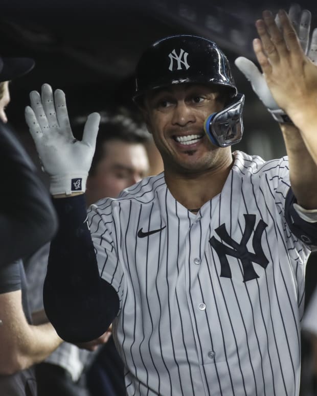 New York Yankees slugger Giancarlo Stanton smiles in dugout after home run