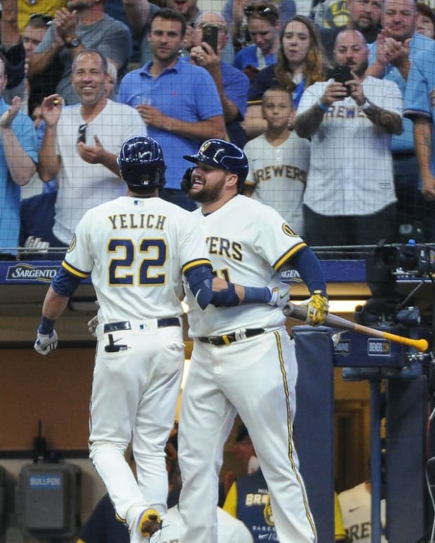 Aug 16, 2022; Milwaukee, Wisconsin, USA; Milwaukee Brewers first baseman Rowdy Tellez (11) chest bumps left fielder Christian Yelich (22) after hitting home run against the Los Angeles Dodgers in the fifth inning at American Family Field. Mandatory Credit: Michael McLoone-USA TODAY Sports