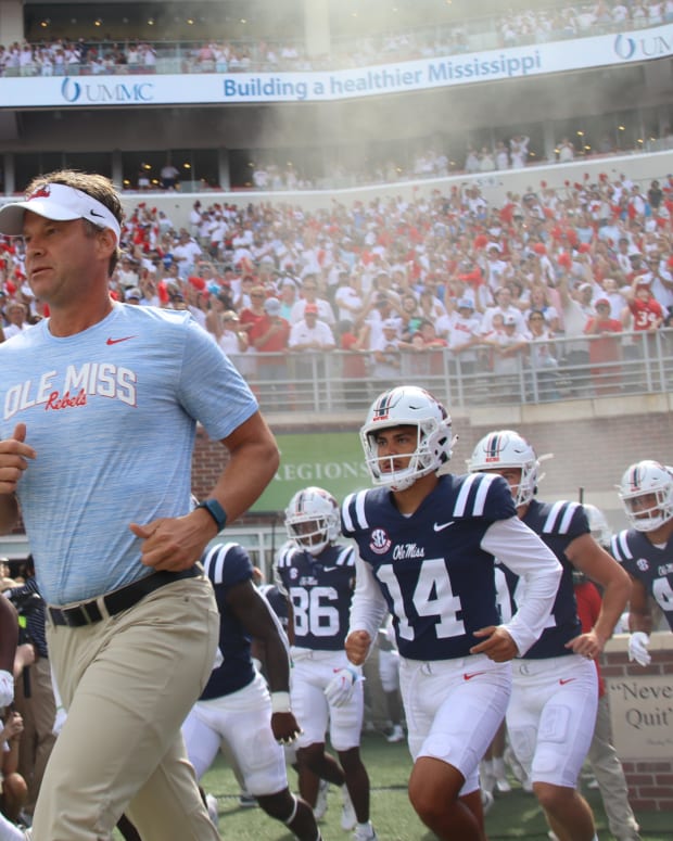 Lane Kiffin running out with Ole Miss Football.