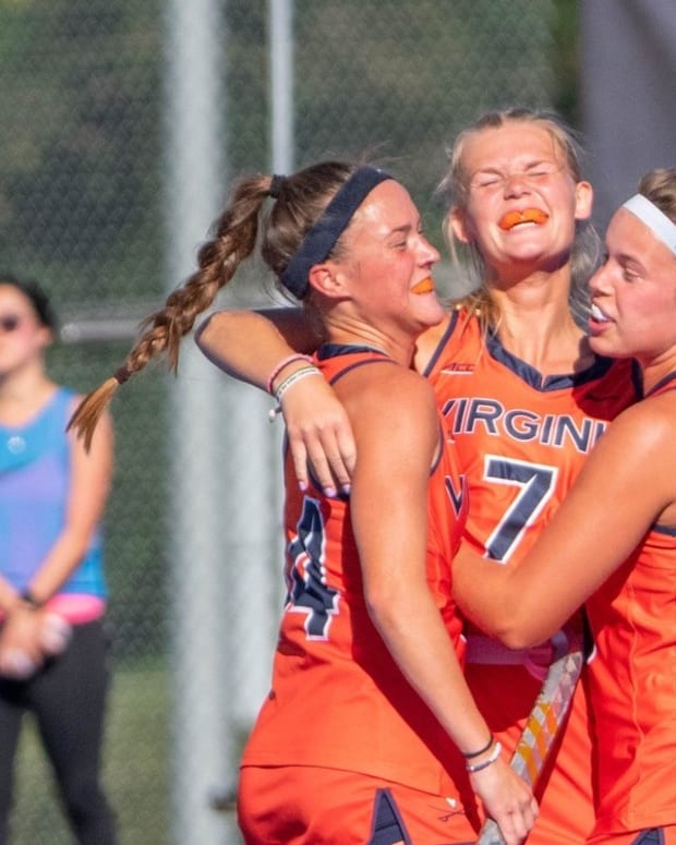 Cato Geusgens celebrates with her team after scoring a goal for the Virginia field hockey team against Syracuse.