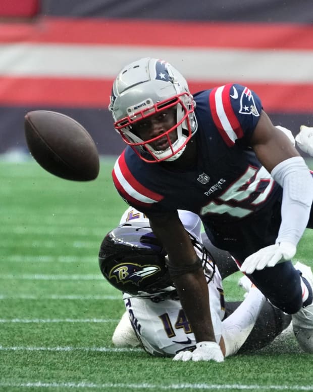 New England receiver Nelson Agholor , being brought down by Raven defender Kyle Hamilton, watches as his fumbled ball bounces away after a 28yard ,4th quarter run. The ball was recovered by the Ravens and ended Patriots chances of a comeback win. Patriots home opener against the Baltimore Ravens on Sept 25, 2022.