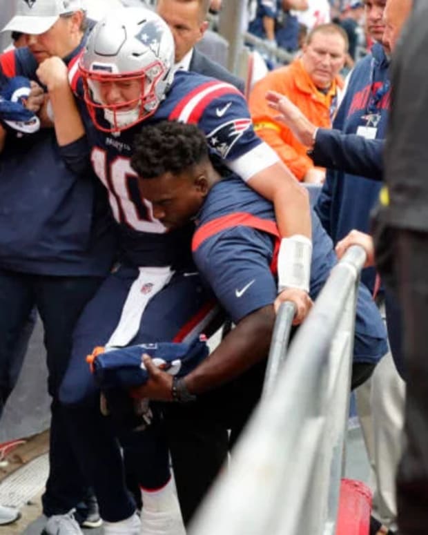 New England Patriots quarterback Mac Jones is helped off the field after suffering a leg injury vs. the Ravens.