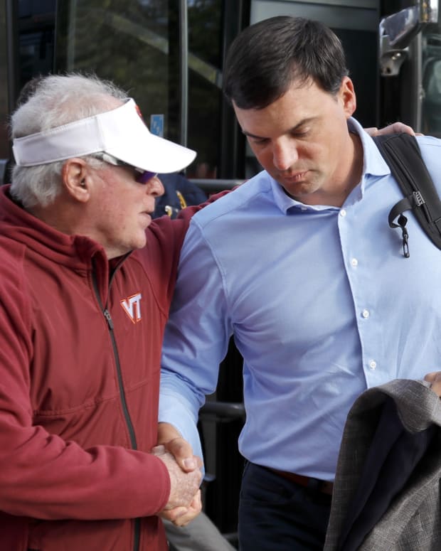 Sep 22, 2022; Blacksburg, Virginia, USA; West Virginia Mountaineers head coach Neal Brown (right) is greeted by Virginia Tech Hokies liaison Denie Marie as he gets off of the team bus before the game at Lane Stadium.