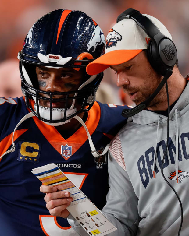 Denver Broncos quarterback Russell Wilson (3) talks with quarterbacks coach Klint Kubiak in the second quarter against the San Francisco 49ers at Empower Field at Mile High.