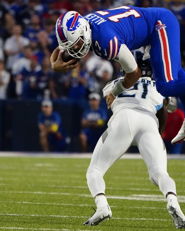 Buffalo Bills quarterback Josh Allen (17) leaps over Tennesse Titans cornerback Roger McCreary (21) running with the ball during the first half at Highmark Stadium.