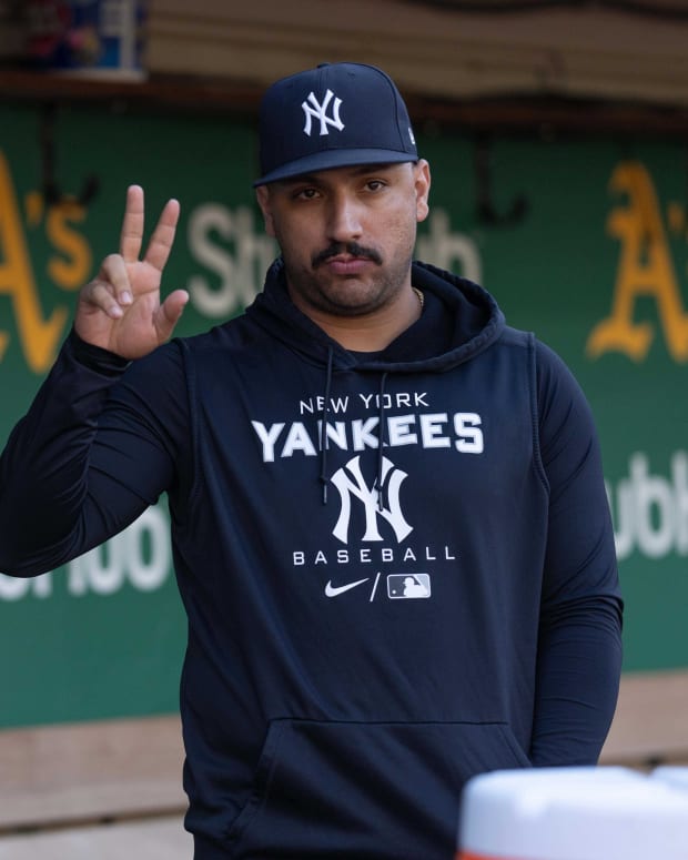 New York Yankees SP Nestor Cortes waves to fans in dugout