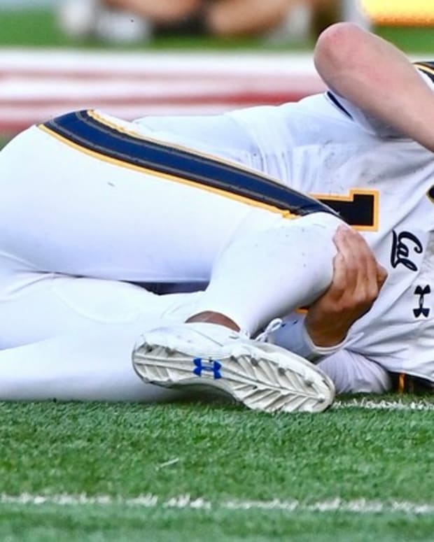 Cal quarterback Jack Plummer grimaces and grabs his knee.