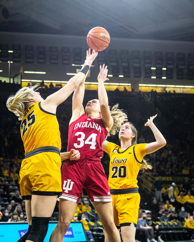 Indiana guard Grace Berger (34) shoots a basket as Iowa center Monika Czinano (25) and Iowa guard Kate Martin (20) defend while Iowa guard Caitlin Clark (22) and Indiana guard Ali Patberg, right, look on during a NCAA Big Ten Conference women's basketball game, Monday, Feb. 21, 2022, at Carver-Hawkeye Arena in Iowa City, Iowa.