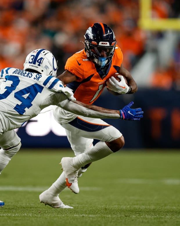 Denver Broncos wide receiver KJ Hamler (1) runs the ball under pressure from Indianapolis Colts cornerback Isaiah Rodgers Sr. (34) in the second quarter at Empower Field at Mile High.