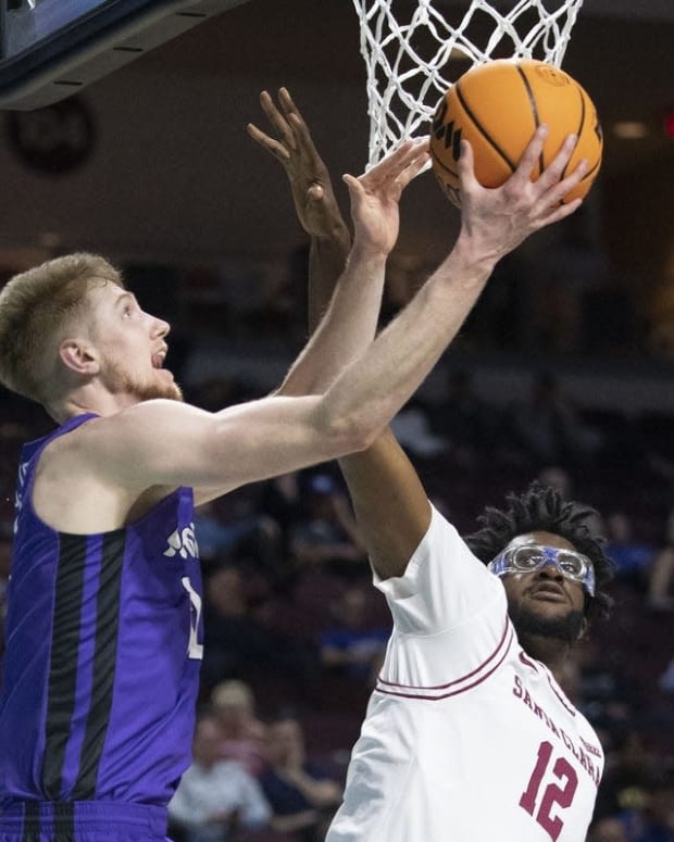 March 5, 2022; Las Vegas, NV, USA; Portland Pilots forward Kristian Sjolund (12) shoots the basketball against Santa Clara Broncos center Jaden Bediako (12) during the first half in the quarterfinals of the WCC Basketball Championships at Orleans Arena. Mandatory Credit: Kyle Terada-USA TODAY Sports