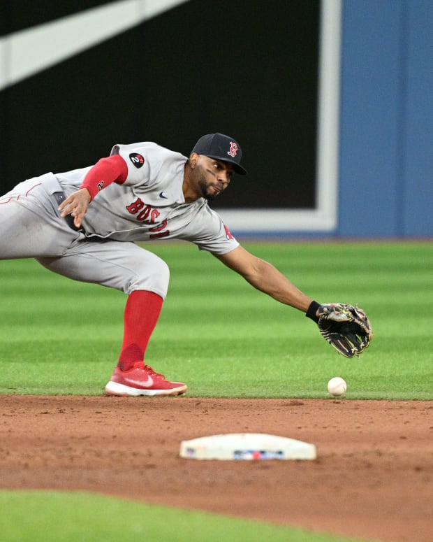 Boston Red Sox shortstop Xander Bogaerts stretches for a ball hit for a single by Toronto Blue Jays right fielder Teoscar Hernandez. (2022)
