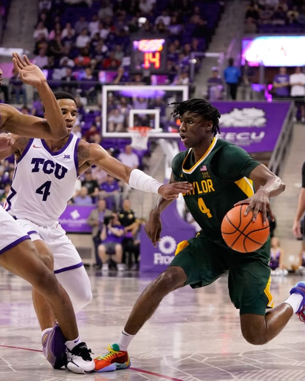 Feb 26, 2024; Fort Worth, Texas, USA; Baylor Bears guard Ja'Kobe Walter (4) dribbles against TCU Horned Frogs forward Xavier Cork (12) and guard Jameer Nelson Jr. (4) during the second half at Ed and Rae Schollmaier Arena. 