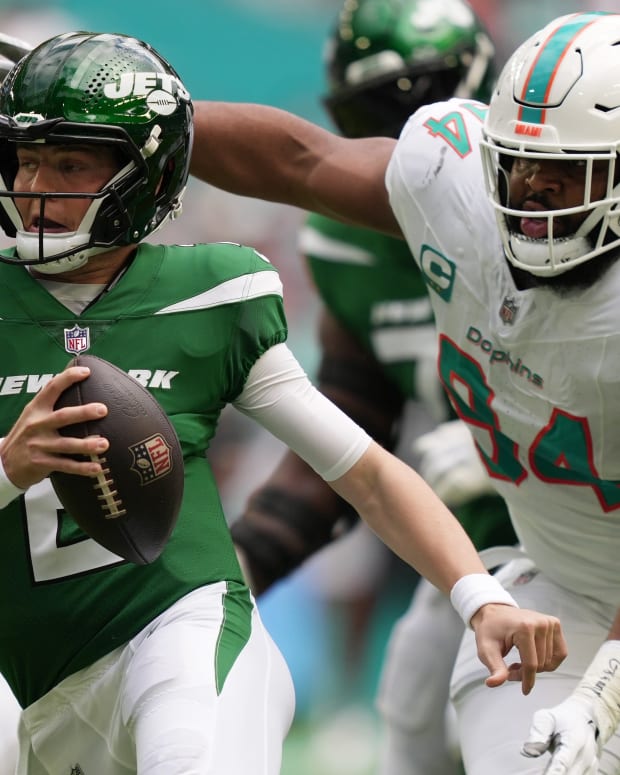 New York Jets quarterback Zach Wilson tries to elude the pressure of Miami Dolphins defensive tackle Christian Wilkins during the first half at Hard Rock Stadium in Miami Gardens, Dec. 17, 2023.