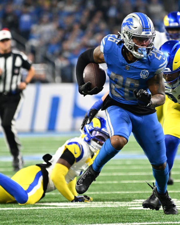 Jan 14, 2024; Detroit, Michigan, USA; Detroit Lions running back Jahmyr Gibbs (26) runs against Los Angeles Rams defensive end Jonah Williams (92) during the first half of a 2024 NFC wild card game at Ford Field.