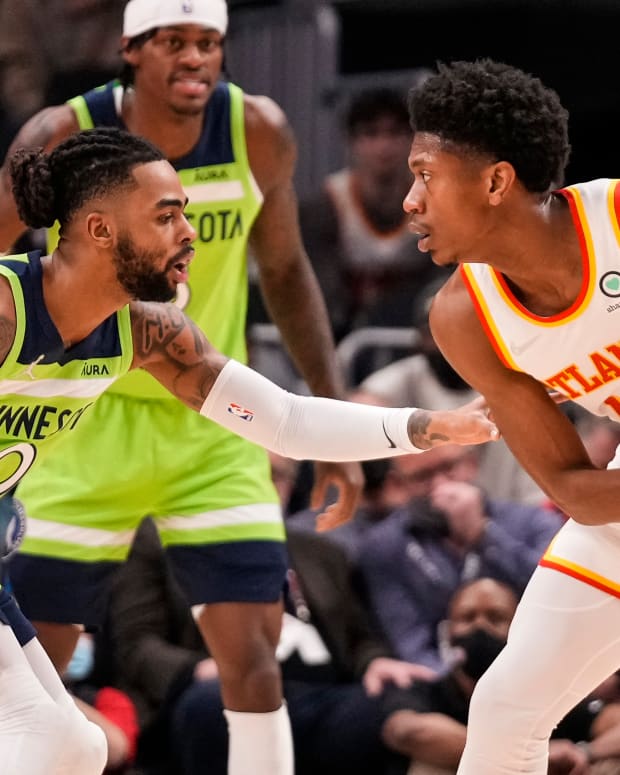 Jan 19, 2022; Atlanta, Georgia, USA; Atlanta Hawks forward De'Andre Hunter (12) protects the ball against Minnesota Timberwolves guard D'Angelo Russell (0) during the first half at State Farm Arena.