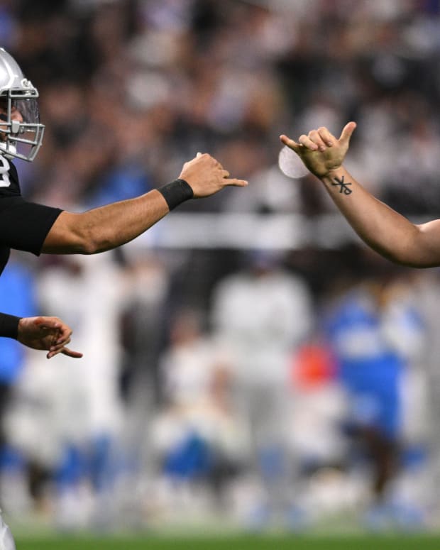 Las Vegas Raiders quarterback Derek Carr (4) celebrates with quarterback Marcus Mariota (8) during the second half against the Los Angeles Chargers at Allegiant Stadium.