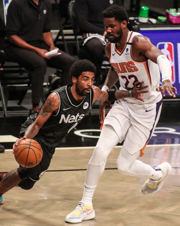 Brooklyn Nets guard Kyrie Irving (11) and Phoenix Suns center Deandre Ayton (22) at Barclays Center.