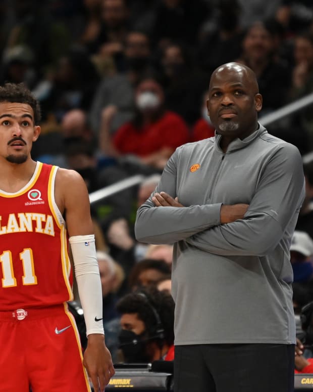 Trae Young standing beside Nate McMillan.