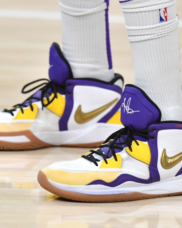 View of white, purple, and gold Nike Kyrie shoes.