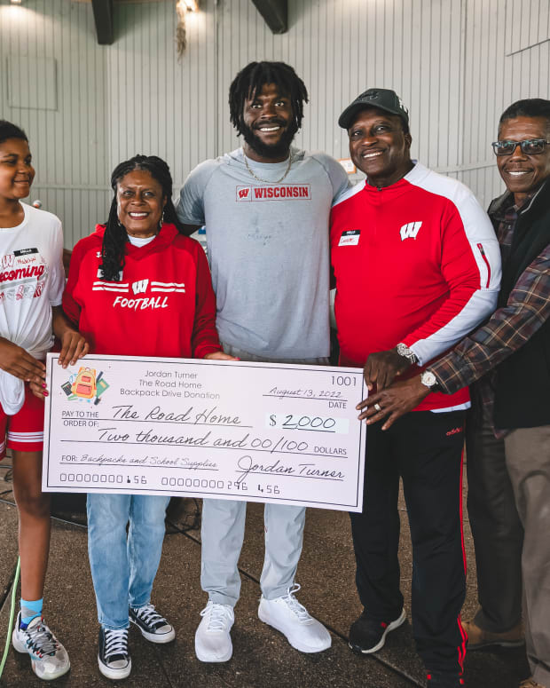 Wisconsin linebacker Jordan Turner presenting a check of $2,000 he donated to The Road Home (Credit: Troy Beckman, Team IFA)