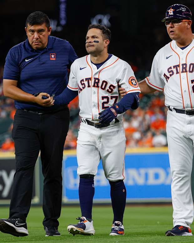 An injured Jose Altuve walks off the field.