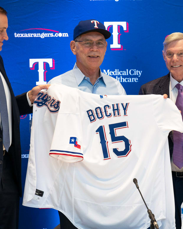 Oct 24, 2022; Arlington, TX, USA; Texas Rangers general manager Chris Young (left) along with managing partner and majority owner Ray Davis (right) presents new team manager Bruce Bochy his Rangers jersey during a news conference at Globe Life Field. Mandatory Credit: Jim Cowsert-USA TODAY Sports