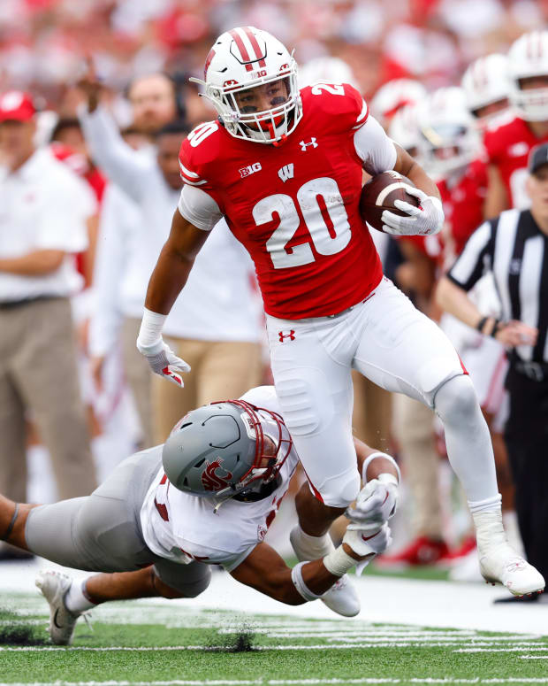 Wisconsin running back Isaac Guerendo running with the football down the sideline against Washington State.