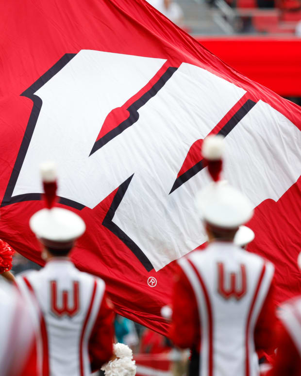 The Wisconsin Badgers flag waving in front of the UW marching band.
