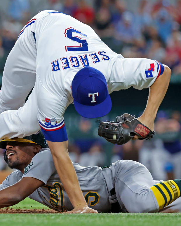Aug 16, 2022; Arlington, Texas, USA; Oakland Athletics left fielder Tony Kemp (5) slides safely into third base ahead of the tag by Texas Rangers shortstop Corey Seager (5) during the first inning at Globe Life Field. Mandatory Credit: Kevin Jairaj-USA TODAY Sports