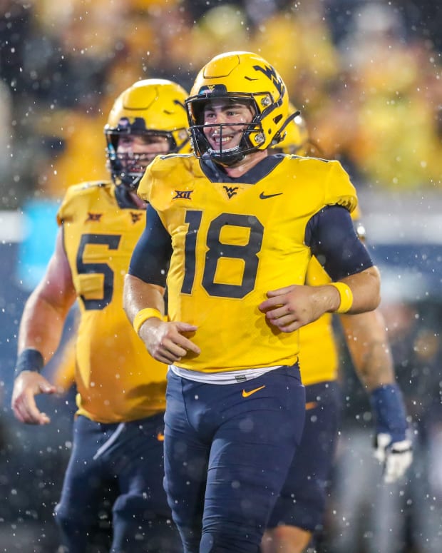 West Virginia Mountaineers quarterback JT Daniels (18) celebrates with teammates after throwing a touchdown pass during the fourth quarter against the Kansas Jayhawks at Mountaineer Field